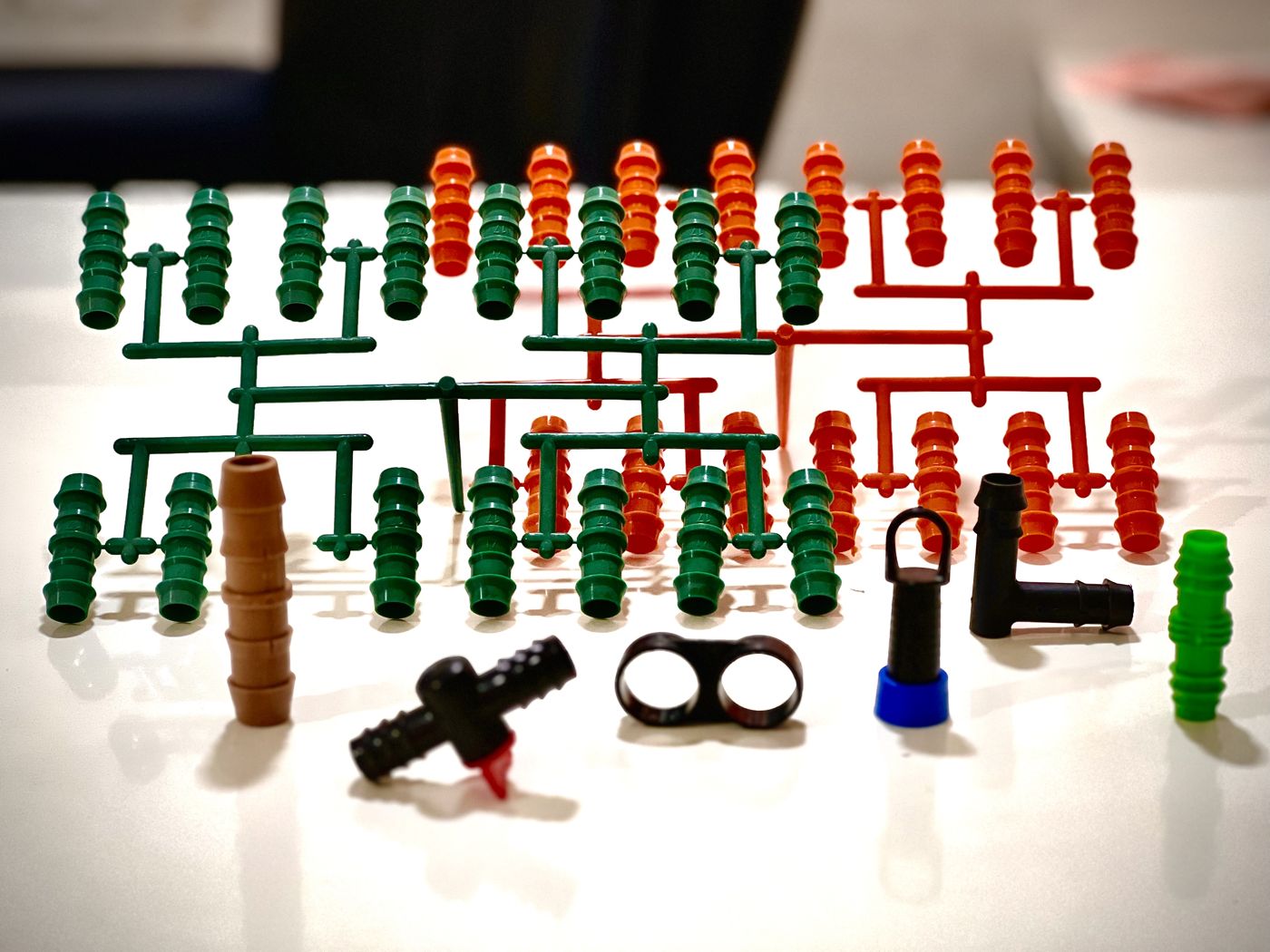 Barbed drip irrigation connectors and takeoff fittings, some still on molding sprues